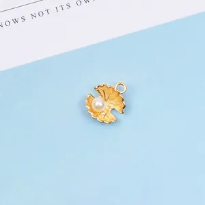Detaillierte Makroansicht eines Goldmuschel-Anhängers mit weißer Perle für DIY-Schmuck
