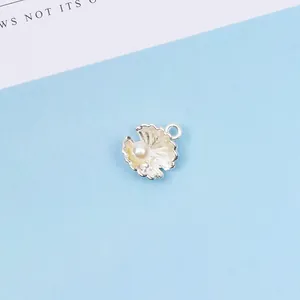 Nahaufnahme eines silbernen Muschel-Anhängers mit Perle für DIY-Schmuck und Haar-Accessoires
