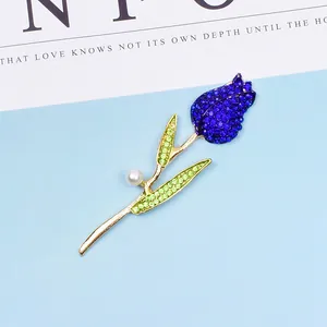 Detail der Tulpenbrosche mit dunkelblauen Steinen, grünen Blättern und runder Perle