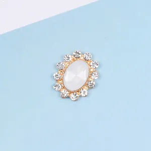Detail of oval alloy decorative buckle with central stone and rhinestones on gold base