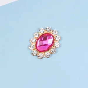 Macro view of pink oval rhinestone with small crystal halo and gold-tone metal backing