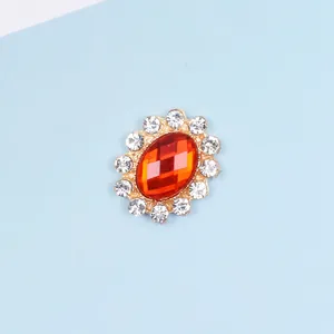 Close-up of red oval crystal alloy button accessory with sparkling white rhinestones