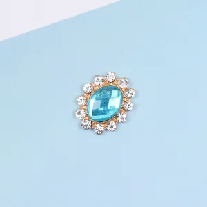Macro detail of oval light blue gemstone accessory with white rhinestone halo in gold