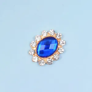 Detail of oval gold alloy buckle with blue diamond gemstone and white rhinestones