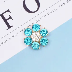 Dettaglio di accessorio floreale in cristallo blu e bianco con base dorata