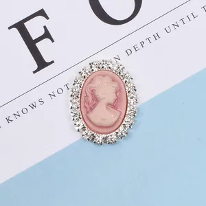 Close-up of pink cameo accessory with ivory relief and shimmering crystal rim
