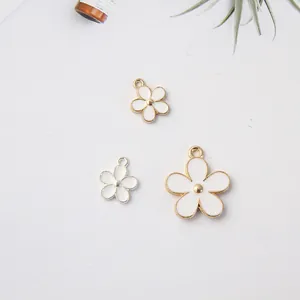 Gros plan de breloques marguerites blanches avec bords dorés et argentés pour bijoux