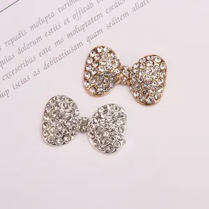 Detailed view of sparkling rhinestone bow charms in gold and silver metal for DIY crafts