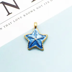 Vista macro de colgante de estrella de mar de esmalte azul con borde dorado y aro superior