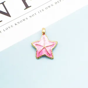Detalle de colgante de estrella de mar en esmalte rosa con borde dorado para joyería DIY