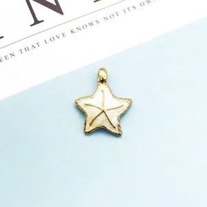Vista macro de colgante de estrella de mar con baño de oro y esmalte blanco