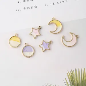 Dettaglio di ciondoli a stella e luna in lega con smalto sfumato per gioielli DIY