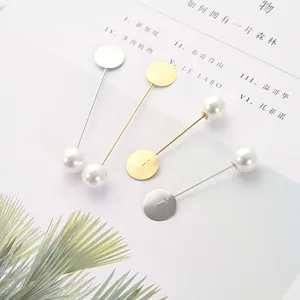 Dettaglio di spilli lunghi in oro e argento con base piatta rotonda e perle eleganti