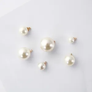 Vue détaillée de pendentifs perles blanc crème avec calottes dorées pour bijoux DIY