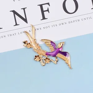 Detailed close-up of a vintage bird and flower brooch with purple enamel finish