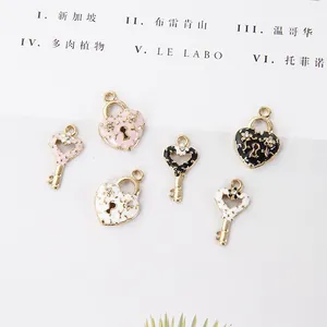 Détail de breloques cadenas cœur et clé en émail coloré avec strass brillants