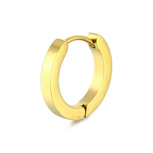 Macro shot of minimalist gold huggie hoop earring with a polished metallic finish