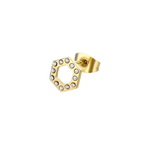 Vue macro d'une boucle d'oreille hexagonale dorée avec cristaux et design géométrique ajouré