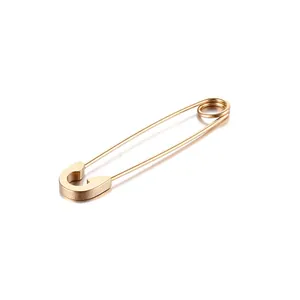 Détail d'une boucle d'oreille trombone en acier inoxydable doré mat de style punk chic