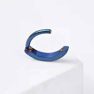 Macro detail of a navy blue titanium steel hinged piercing ring on white stone