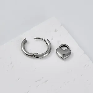 Detailed macro view of silver stainless steel hoop earring with heart lock pendant