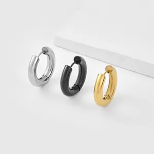 Close-up of polished thick hoop earrings in silver, black, and gold finishes