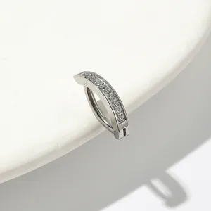 Detailed view of silver curved belly ring featuring a micro-paved row of clear zircons