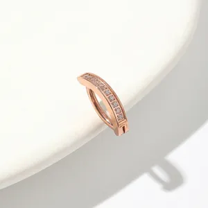 Detailed macro view of rose gold navel piercing ring with paved cubic zirconia stones