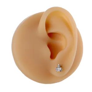 Close-up of silver crown stud earring with micro-set zircon stones on a model ear