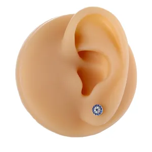 Exquisite evil eye stud earrings with blue and white zircon stones on silicone ear model