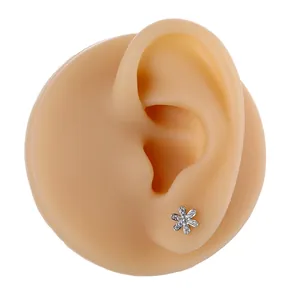 Elegant six-petal flower stud earring with micro-pave zircons on a model's ear