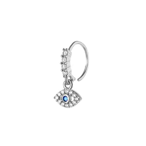 Macro detail of silver evil eye nose ring with blue crystal and shimmering zircons