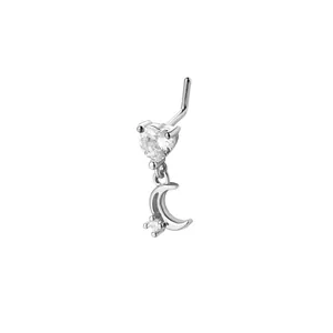 L-shaped nose stud detail featuring a sparkling heart stone and crescent moon dangle pendant