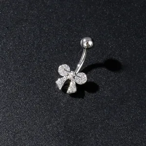 Macro detail of silver butterfly belly ring with sparkling cubic zirconia on dark surface