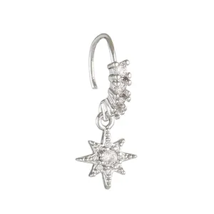 Detail of silver nose ring with cubic zirconia cross and hanging eight-pointed star charm