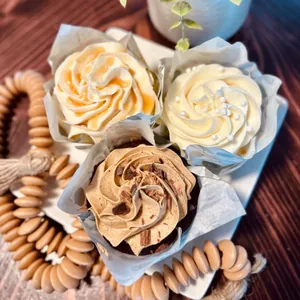 Vue de dessus de caissettes tulipes pour muffins avec glaçage sur un plateau blanc