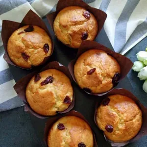 Makroaufnahme von 6 frisch gebackenen Muffins in dunkelbraunen Tulpen-Backförmchen