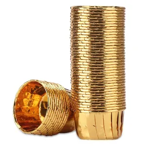 Macro view of gold foil muffin liners with pleated edges and metallic mirror finish