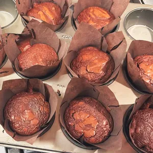 Vista macro de moldes tulipán marrones con cupcakes de chocolate en una bandeja de horno