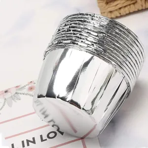 Macro detail of silver aluminum foil muffin cups with metallic texture on marble background
