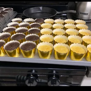 Detailweergave van gouden muffinbakjes met cupcakes op een bakplaat in de oven
