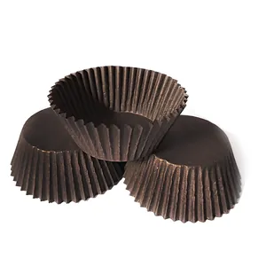 Detail of dark brown greaseproof paper cake liners showing pleated edges and flat base