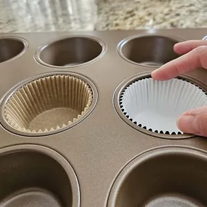 Primer plano de moldes de papel para muffins antigrasa en marfil y marrón en una bandeja