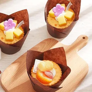 Detalle de moldes de papel para cupcakes tipo tulipán marrón con frutas y flores decorativas