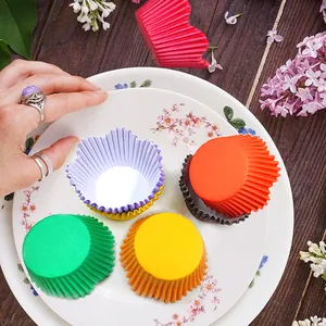 Detailaufnahme bunter, fettbeständiger Cupcake-Förmchen aus Papier auf einem Teller