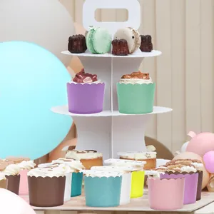 Soporte blanco de tres niveles para cupcakes con moldes coloridos para mesa de postres