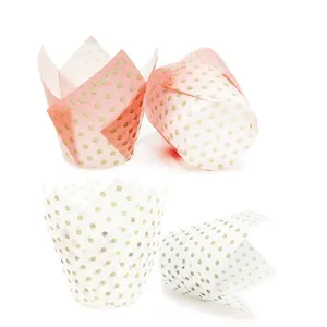 Macro view of pink and white tulip cupcake liners with golden dot patterns on paper