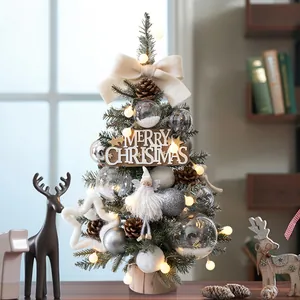 Mini tabletop Christmas tree with LED lights and white festive ornaments on wood base
