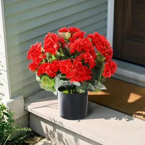 Geranios artificiales rojos realistas en una maceta negra para decoración de jardín