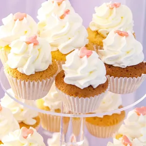 Close-up of frosted cupcakes with pink hearts on a tiered display stand